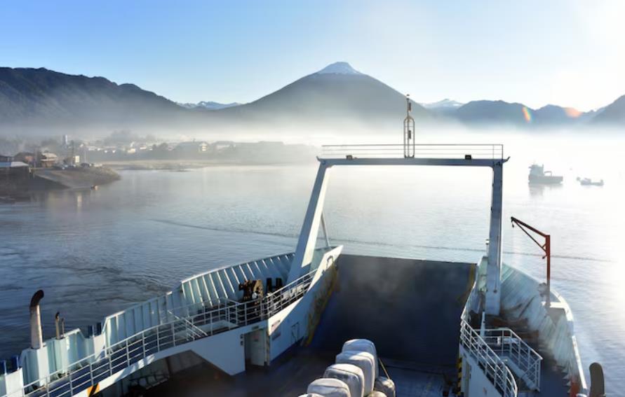 造船外贸视角下的船舶航行场景 远山雾景与航运设施展现造船业全球布局潜力。