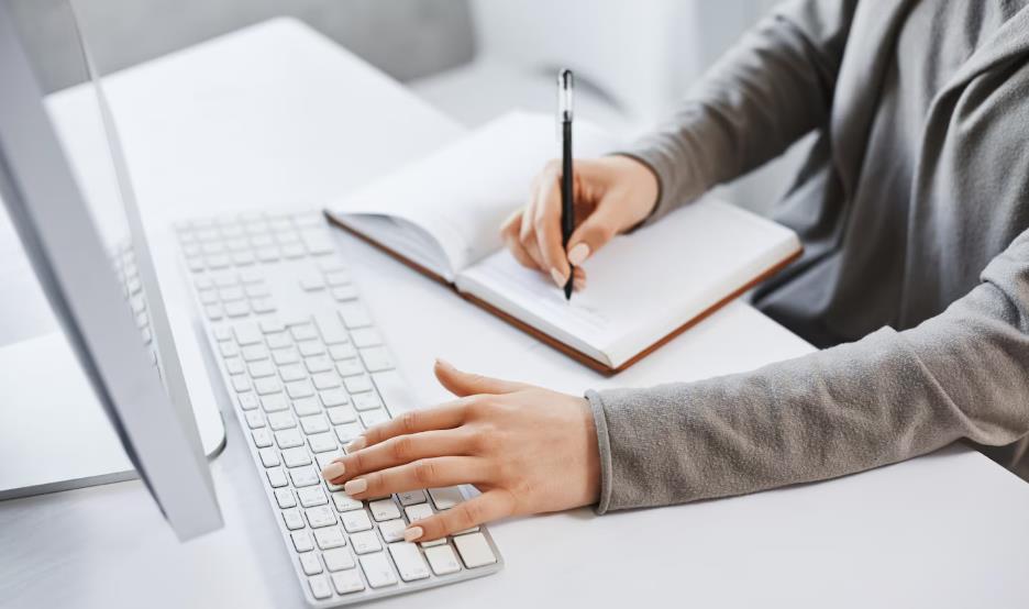 双手在笔记本电脑上操作,展现内容创作者频繁更新内容却遭遇流量下降的场景,用于解析 “内容更新频繁但流量反而下降” 的 SEO 与运营问题视觉说明